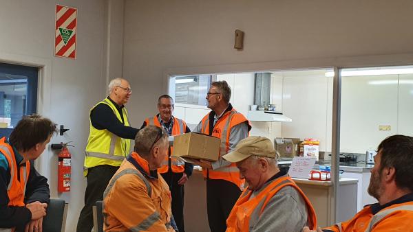 Chris van der Werff then presents John with some goods from NZI 